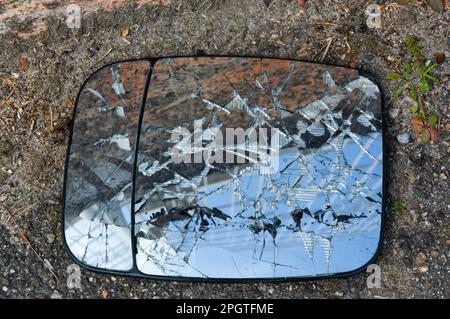 Un miroir de voiture cassé se trouve sur le sol d'une zone industrielle de Valence, en France Banque D'Images