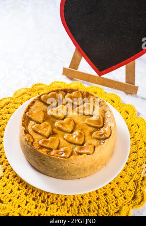 Une délicieuse tarte fraîchement cuite au cœur et une assiette blanche au premier plan Banque D'Images