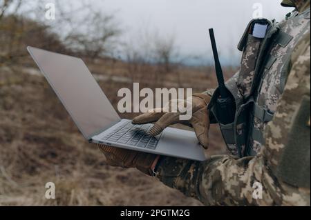 Un soldat travaille sur son ordinateur portable. Banque D'Images