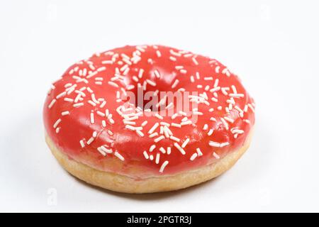 Grand donut avec glaçure rouge et parsemé sur un fond blanc d'isolat Banque D'Images