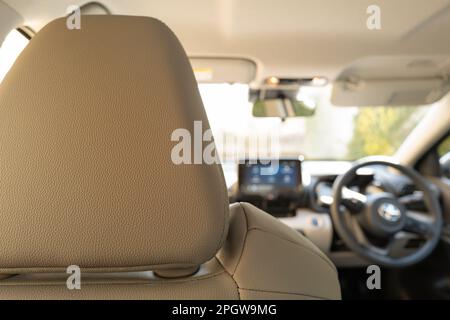 Mise au point à distance d'un intérieur de voiture à technologie hybride moderne montrant la direction et le grand panneau de navigation à écran tactile. Vue depuis le siège arrière. Banque D'Images