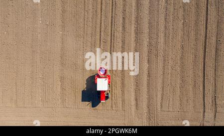 Vue de dessus du tracteur en position de lancement, fertilisation des terres arables pour les nouvelles récoltes, machine agricole traînante pour l'épandage de fertilisants artificiels Banque D'Images