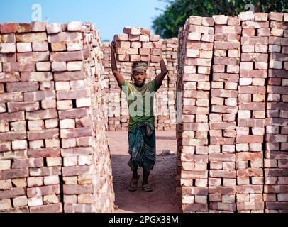 24 mars 2023, West Tootpara, Khulna, Bangladesh: Les gens travaillent dans le champ de briques, le travail dans un champ de briques peut être physiquement exigeant et peut impliquer de longues heures d'exposition à la chaleur, à la poussière et à d'autres dangers environnementaux. Dans les pays de la Bnagladesh, travailler dans des champs de briques est souvent considéré comme un emploi peu rémunéré et exigeant beaucoup de main-d’œuvre, et les travailleurs peuvent être confrontés à de mauvaises conditions de travail, à une faible sécurité d’emploi et à des opportunités d’avancement limitées. Toutefois, certains organismes et gouvernements travaillent à améliorer les conditions de travail et à promouvoir des pratiques plus durables et éthiques dans l'industrie de la brique. Banque D'Images