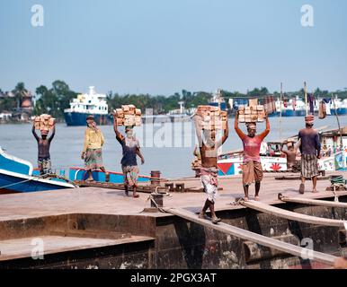 24 mars 2023, West Tootpara, Khulna, Bangladesh: Les gens travaillent dans le champ de briques, le travail dans un champ de briques peut être physiquement exigeant et peut impliquer de longues heures d'exposition à la chaleur, à la poussière et à d'autres dangers environnementaux. Dans les pays de la Bnagladesh, travailler dans des champs de briques est souvent considéré comme un emploi peu rémunéré et exigeant beaucoup de main-d’œuvre, et les travailleurs peuvent être confrontés à de mauvaises conditions de travail, à une faible sécurité d’emploi et à des opportunités d’avancement limitées. Toutefois, certains organismes et gouvernements travaillent à améliorer les conditions de travail et à promouvoir des pratiques plus durables et éthiques dans l'industrie de la brique. Banque D'Images