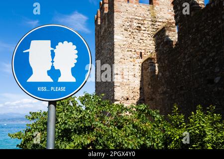 Panneau rue KISS situé dans la zone publique en face du château de Sirmione, Italie. Concept d'amour, couple, romantique Banque D'Images