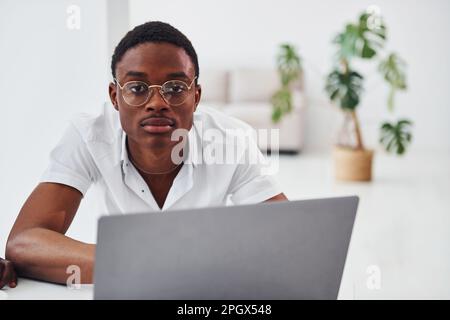 Un jeune afro-américain vêque de manière formelle est au bureau Banque D'Images