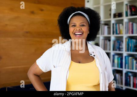 Portrait d'une femme afro-américaine heureuse et de grande taille, regardant l'appareil photo et souriant Banque D'Images