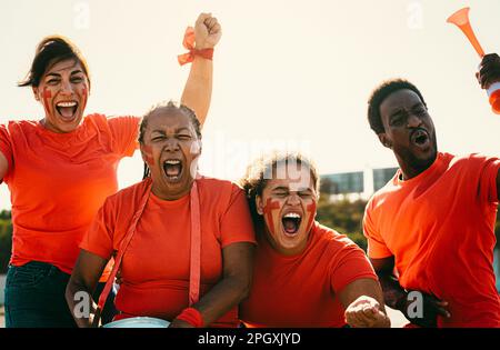 Les fans de football rouge s'amusent à encourager leur équipe préférée - concept de divertissement de sport de football Banque D'Images