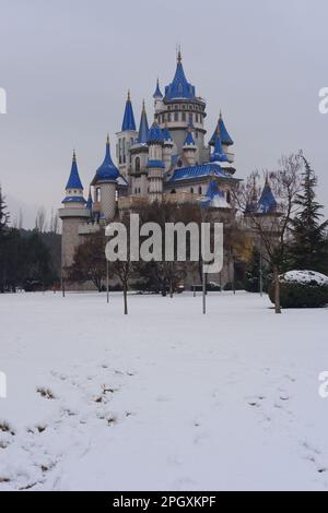 Château rétro nostalgique dans le parc de Sazova Eskisehir avec des tours bleues. Sous la neige en hiver, avec des arbres et des buissons sous la neige. Banque D'Images