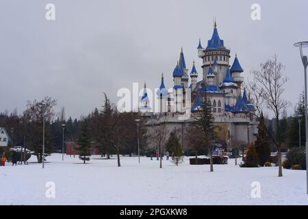 Château rétro nostalgique dans le parc de Sazova Eskisehir avec des tours bleues. Sous la neige en hiver, avec des arbres et des buissons sous la neige. Banque D'Images