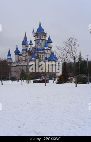 Château rétro nostalgique dans le parc de Sazova Eskisehir avec des tours bleues. Sous la neige en hiver, avec des arbres et des buissons sous la neige. Banque D'Images