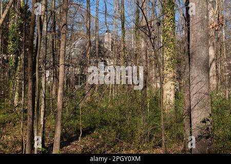 Manoir caché niché dans les bois, partiellement caché de la vue. Immobilier et concept de propriété. Banque D'Images