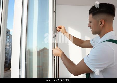 Un employé pose une bande de traction en caoutchouc sur la fenêtre à l'intérieur Banque D'Images