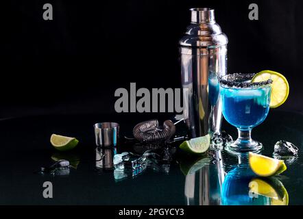 Une margarita bleue garnie de sel noir hawaïen et de lime. Banque D'Images