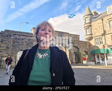 St. Andrews, Royaume-Uni. 24th mars 2023. Jane Philips, activiste indépendante de Dundee, se dresse devant une arche et un drapeau écossais dans la ville écossaise de St. Andrews. Elle est impliquée dans un groupe local pour l'indépendance écossaise. (À dpa-KORR: 'Quelle sortie du royaume? L'Écosse cherche une nouvelle boussole") Credit: Larissa Schwedes/dpa/Alay Live News Banque D'Images