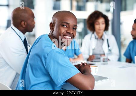 Bien vous guérir ensemble. Portrait d'un jeune médecin ayant une réunion avec ses collègues dans une salle de conférence de l'hôpital. Banque D'Images