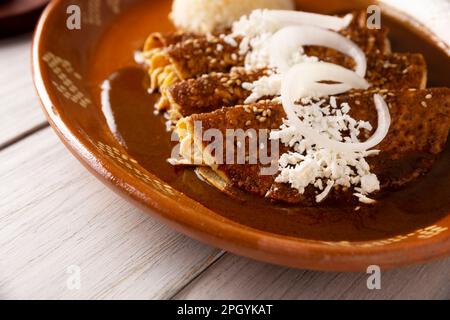 Enmoladas de poulet. Aussi connu sous le nom de mole poblano enchiladas, ils sont un plat mexicain typique qui est très populaire au Mexique et dans le reste du monde. Banque D'Images