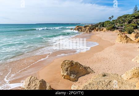 Les vagues de l'Atlantique roulent à terre sur la plage déserte de Praia da Galé près d'Albufeira, Algarve Portugalee Banque D'Images