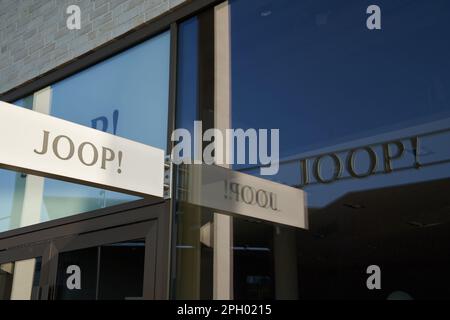 Metzingen, Allemagne - Mai 03, 2021: Marque de mode Joop. Lettres sur un signe, reflétées plusieurs fois dans le verre. Vue latérale. Banque D'Images