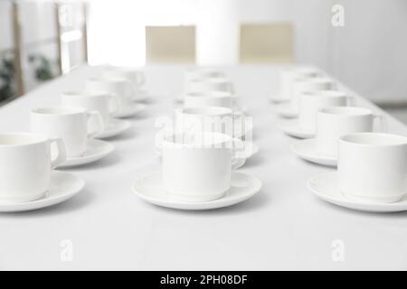 Beaucoup de tasses vides sur table blanche à l'intérieur pour la pause-café Banque D'Images