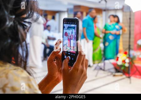 Une cliente qui prend des photos avec son téléphone portable à l'engagement Party à l'hôtel Shaans, Trichy, Tamil Nadu, Inde Banque D'Images