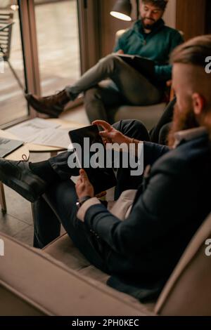 Homme long et barbu travaillant sur la tablette. Gros plan Banque D'Images