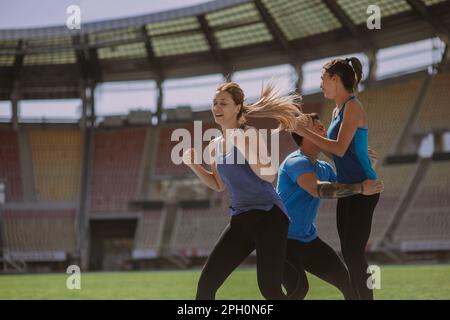 Les sportifs masculins et féminins fêtent leurs festivités parce qu'ils ont terminé leur entraînement de course à pied à temps Banque D'Images