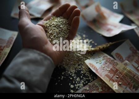 Le concept du coût du grain. 5000 roubles de billets autour d'une poignée de grain de terre. La faim dans le monde. Banque D'Images