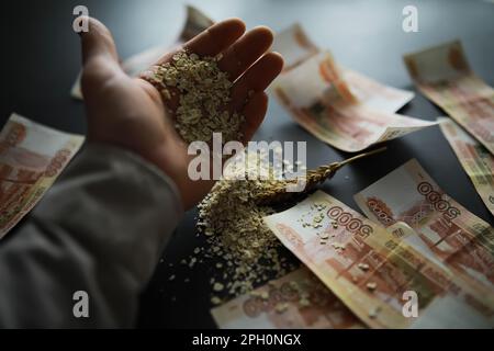 Le concept du coût du grain. 5000 roubles de billets autour d'une poignée de grain de terre. La faim dans le monde. Banque D'Images