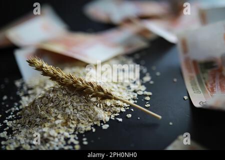 Le concept du coût du grain. 5000 roubles de billets autour d'une poignée de grain de terre. La faim dans le monde. Banque D'Images