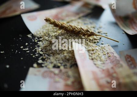 Le concept du coût du grain. 5000 roubles de billets autour d'une poignée de grain de terre. La faim dans le monde. Banque D'Images