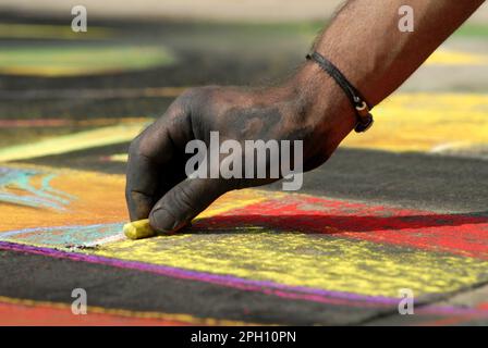 Un artiste fait de belles œuvres d'art dans la rue en utilisant la craie pastel tout en assistant au festival Madonnari Banque D'Images