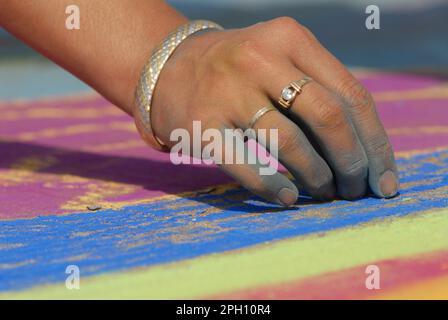 Un artiste fait de belles œuvres d'art dans la rue en utilisant la craie pastel tout en assistant au festival Madonnari Banque D'Images