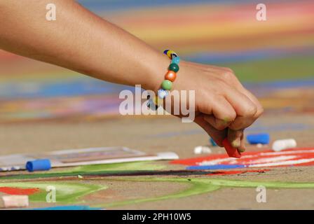 Un artiste fait de belles œuvres d'art dans la rue en utilisant la craie pastel tout en assistant au festival Madonnari Banque D'Images