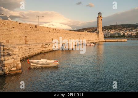 Le soleil du soir réchauffe le mur et le phare de l'ancien port vénitien de Rethymnon, Crète, Grèce Banque D'Images