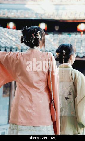 Deux femmes portant des vêtements traditionnels chinois orientaux marchant dans une rue historique Banque D'Images