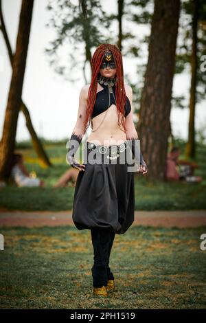 Danse mythologique fille faun sur la pelouse verte dans le parc public événement de danse artistique en plein air avec une atmosphère mythologique. Fille à l'image de créature mythique Banque D'Images