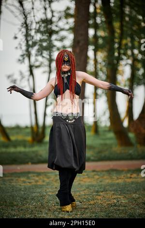 Danse mythologique fille faun sur la pelouse verte dans le parc public événement de danse artistique en plein air avec une atmosphère mythologique. Fille à l'image de créature mythique Banque D'Images