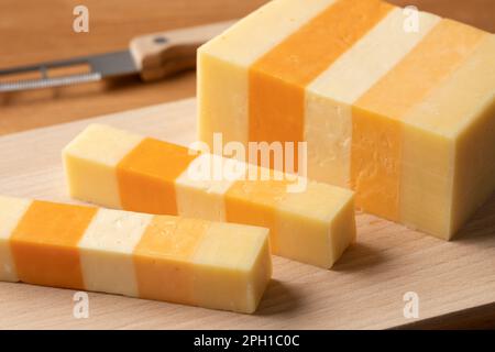 Morceau de French Classic Five, variante de fromage cheddar, sur une planche à découper pour un en-cas de près Banque D'Images