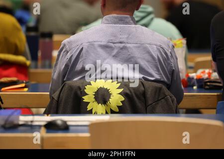 25 mars 2023, Schleswig-Holstein, Neumünster : un tournesol est imprimé sur la veste d'un participant à la conférence d'État du Parti Vert du Schleswig-Holstein. Les Verts cherchent la deuxième place dans l'État pour les élections locales sur 14 mai 2023. À Neumünster, ils discutent de divers sujets, de la transition énergétique à la mobilité et des demandes d'interdiction des pétards. Photo: Frank Molter/dpa Banque D'Images