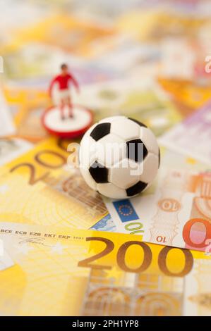 ballon de football et billets en euros, le sport comme concept d'affaires Banque D'Images