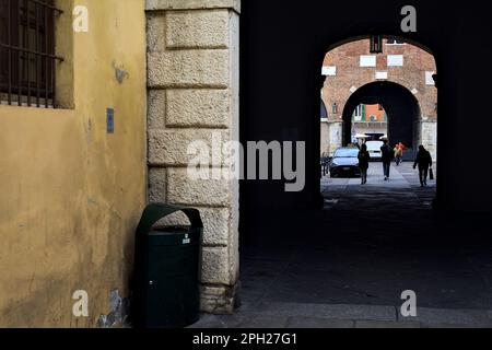 Allée couverte à l'ombre entre les places dans une ville italienne avec des gens passant Banque D'Images