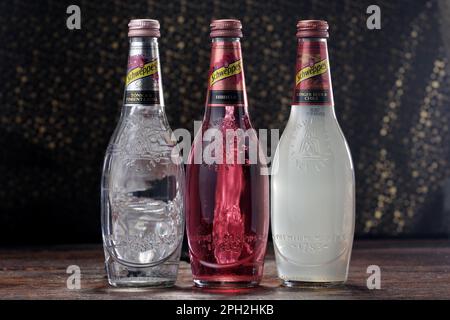 Koszalin, Pologne, 25 mars 2023. Bouteille en verre Schweppes sur fond abstrait. Logo Schweppes. Photo de bouteilles aux saveurs différentes de Schwepp Banque D'Images