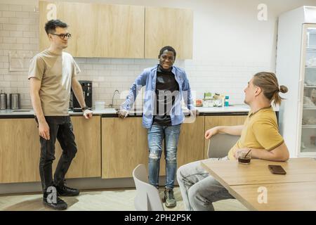 Groupe de jeunes joyeux qui parlent et sourient pendant les pauses-café au bureau. Une équipe de développeurs de logiciels professionnels se détendant dans le Banque D'Images