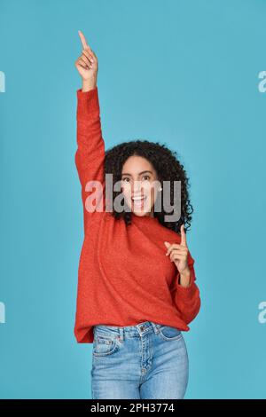 Jeune heureuse femme latine funky ayant l'amusement dansant isolé sur bleu. Banque D'Images