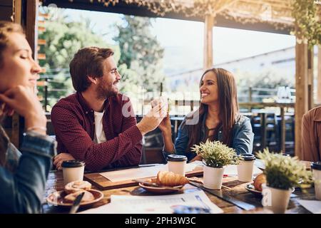 Santé à la bonne nourriture et à de bonnes personnes. des amis qui s'amusent pendant leur déjeuner. Banque D'Images