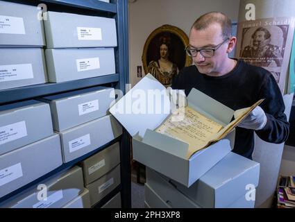 PRODUCTION - 21 mars 2023, Saxe-Anhalt, Halle (Saale): Jens Wehmann, bibliothécaire à la Maison du Handel à Halle/Saale, présente des documents historiques du 1940s dans les archives de la Maison du Handel. Les archives du musée et lieu de naissance du compositeur baroque George Frideric Handel (1685-1759) sont conservées pour la postérité. Environ 200 boîtes de fichiers ont été désacidifiées et ainsi sauvées de la décomposition du papier. Les dossiers comprennent la correspondance des directeurs de la Maison Handel, la correspondance sur les achats, l'organisation du Festival Handel et des documents sur l'organisation de l'exposition Banque D'Images