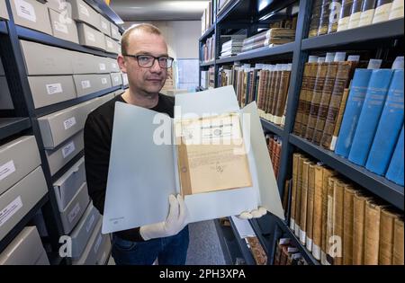 PRODUCTION - 21 mars 2023, Saxe-Anhalt, Halle (Saale): Jens Wehmann, bibliothécaire à la Maison du Handel à Halle/Saale, présente des documents historiques du 1940s dans les archives de la Maison du Handel. Les archives du musée et lieu de naissance du compositeur baroque George Frideric Handel (1685-1759) sont conservées pour la postérité. Environ 200 boîtes de fichiers ont été désacidifiées et ainsi sauvées de la décomposition du papier. Les dossiers comprennent la correspondance des directeurs de la Maison Handel, la correspondance sur les achats, l'organisation du Festival Handel et des documents sur l'organisation de l'exposition Banque D'Images