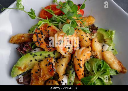 Crevettes grillées, avocat et salade de tomates nappées d'œufs de caille Banque D'Images