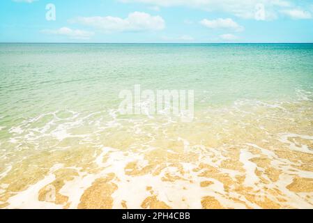Plage de sable doré et eaux de mer turquoise. Vagues douces sur la rive de la mer. Banque D'Images